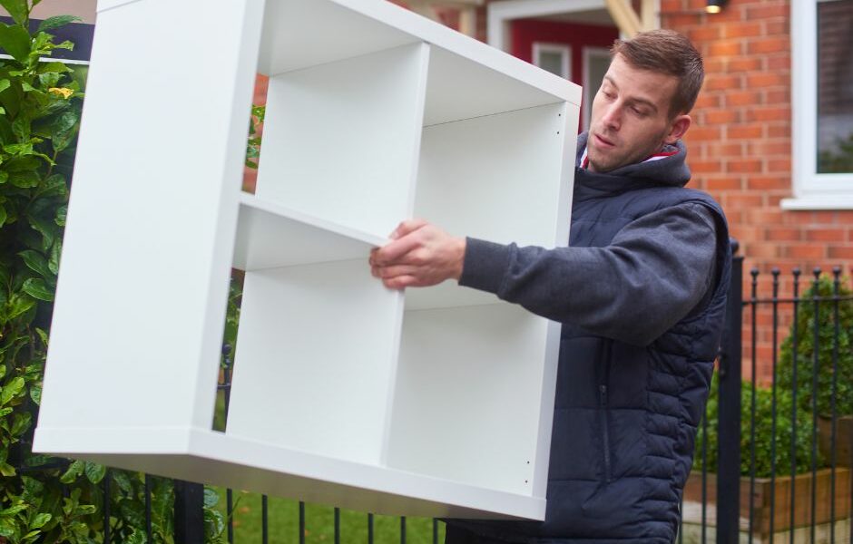 Furniture removal, a man taking a heavy shelving unit out of a home